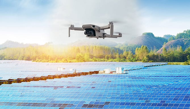 Drone sobrevoando painéis de energia solar em terreno plano